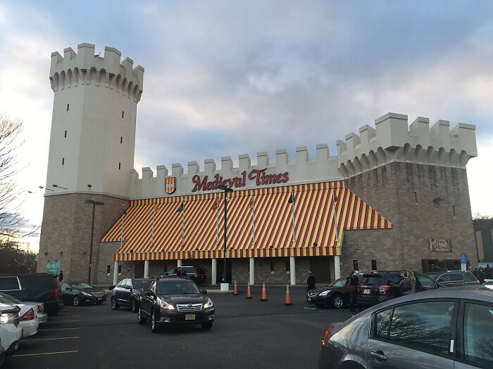 Medieval Times castle-themed dinner theater with striped awnings and parking lot