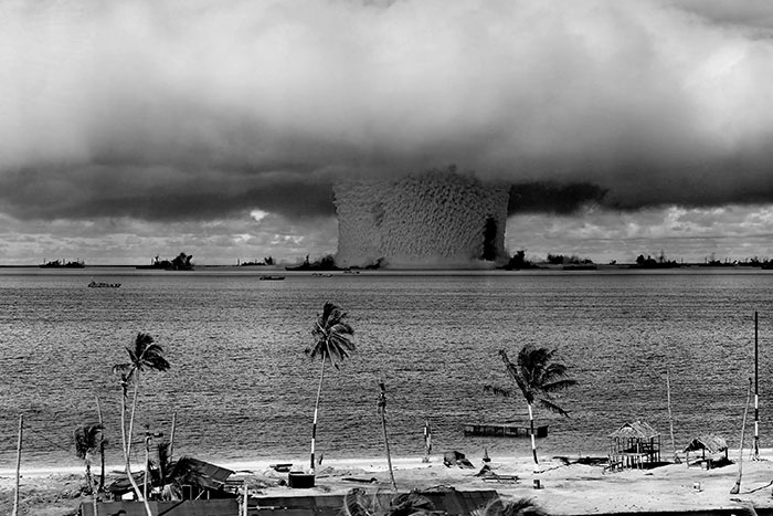 Devastating nuclear explosion creating mushroom cloud over water