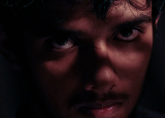 Close-up of a man's face with intense eyes and dark shadows, killer profile concept