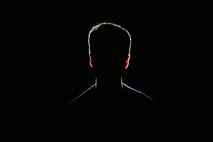 Silhouette of person in dark background with backlight