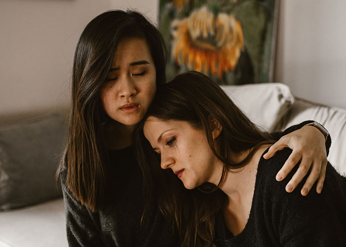 Two women embracing, one comforting the other, showing that Family Isn't Everything, and support is crucial.