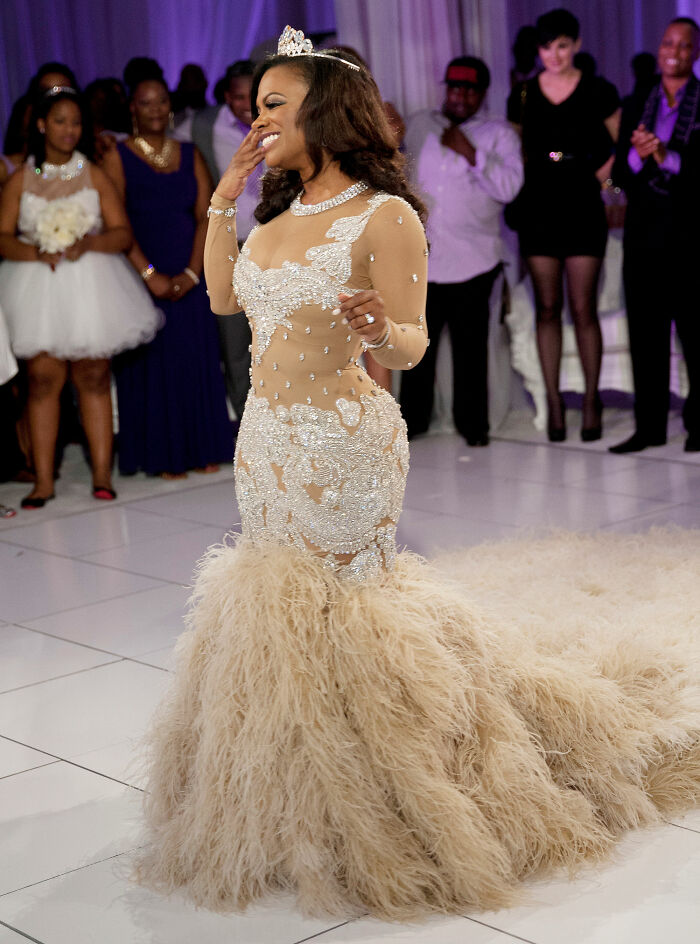 Kandi Burruss radiates joy in her unique feathered celebrity wedding dress, a stunning statement gown on her special day.