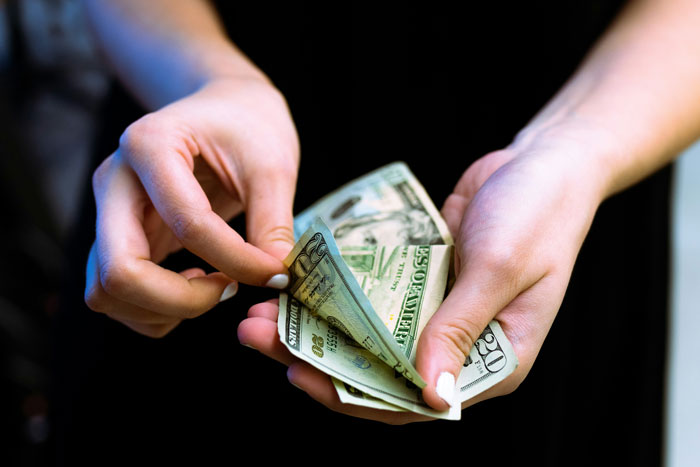 Hands counting US dollar bills