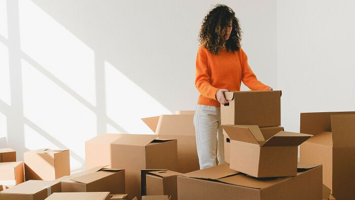 Woman packing cardboard boxes indicating challenge of moral dilemmas