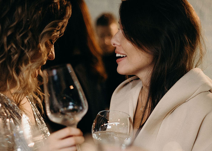 Two women talking and laughing, representing close friends before trust is broken.