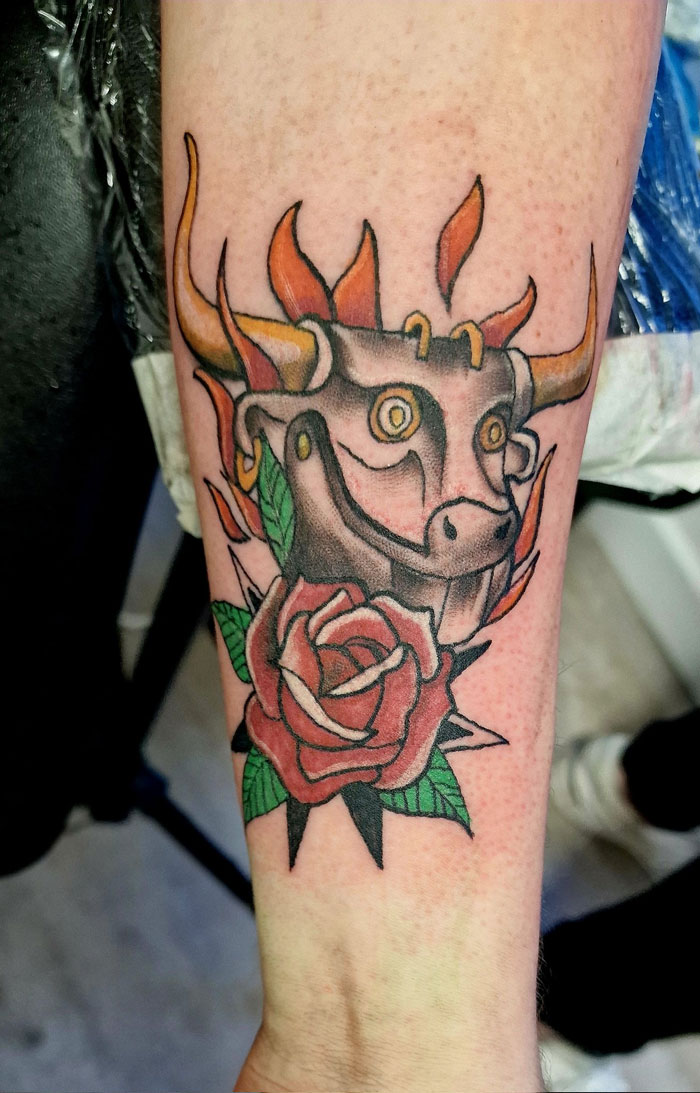 A tattoo artist's talent is shown with a bull head and rose tattoo, a questionable idea.