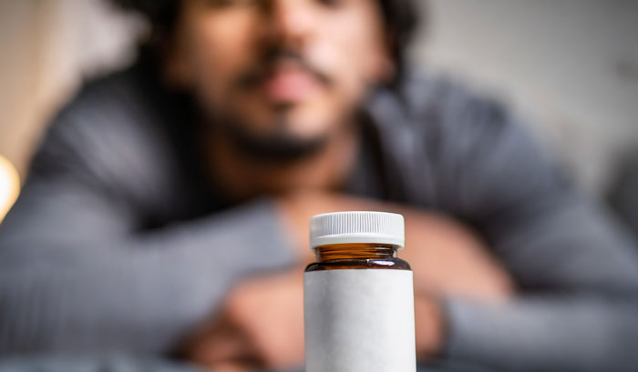 Man focused on medicine bottle in healthcare setting