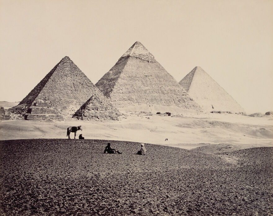 Pyramids Of Giza with people and a donkey in the foreground