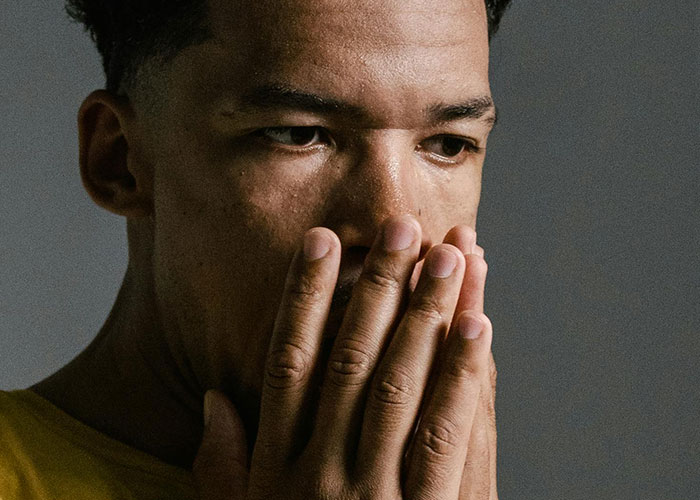 Worried man covering mouth thinking about killers