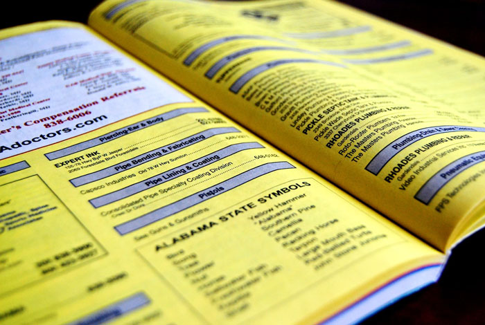 Yellow pages directory open showing listings and Alabama state symbols