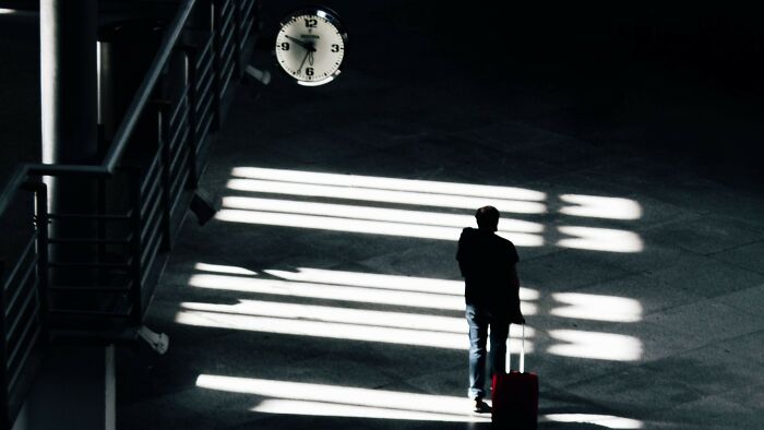 Silhouette of a person with luggage under clock showing time for moral dilemmas