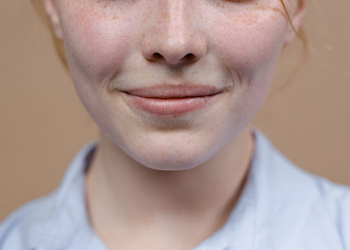 A smiling person with freckles, demonstrating how unserious solutions can bring joy.
