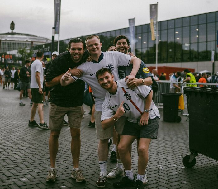 Four friends in sports jerseys posing outdoors, enjoying a plane interaction moment.
