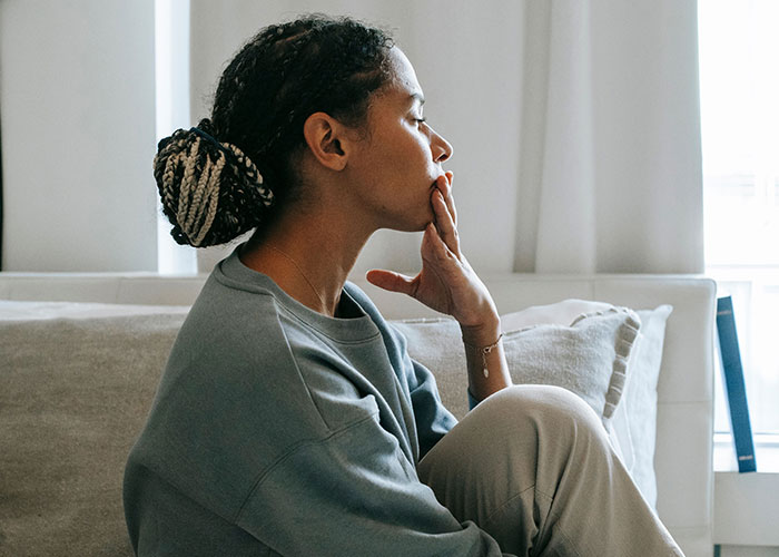 A woman looking distant, experiencing broken trust from close friends.