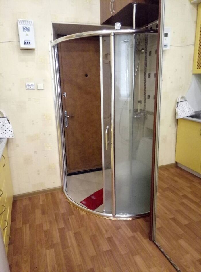 A shower stall placed directly in front of an apartment door, a clear architecture and design fail.