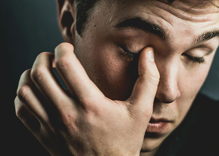 Close-up of man rubbing eyes tiredly, representing wild secrets