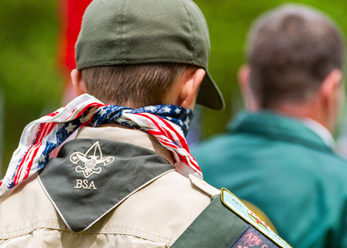 Boy scout wearing uniform with American flag neckerchief