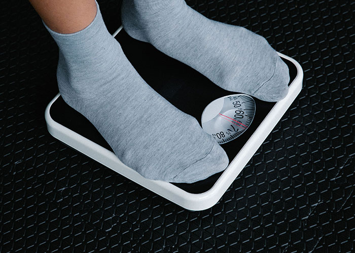 A person standing on a scale, showing that Family Isn't Everything, but personal health is vital.
