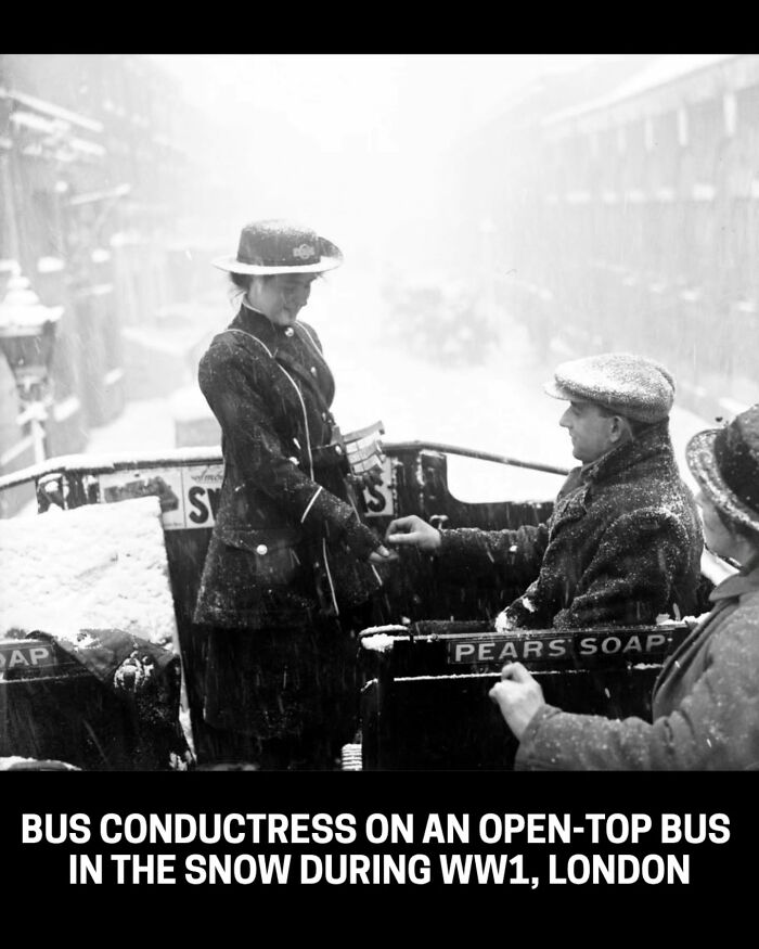 A bus conductress on an open-top bus in the snow during WW1, London, an interesting historical photo.