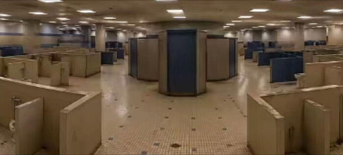 An expansive, haunting liminal space resembling a locker room or public bathroom with many stalls.