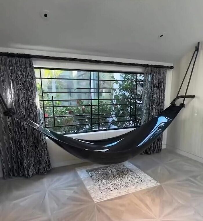 Black hammock with sleek design suspended in a minimalistic room