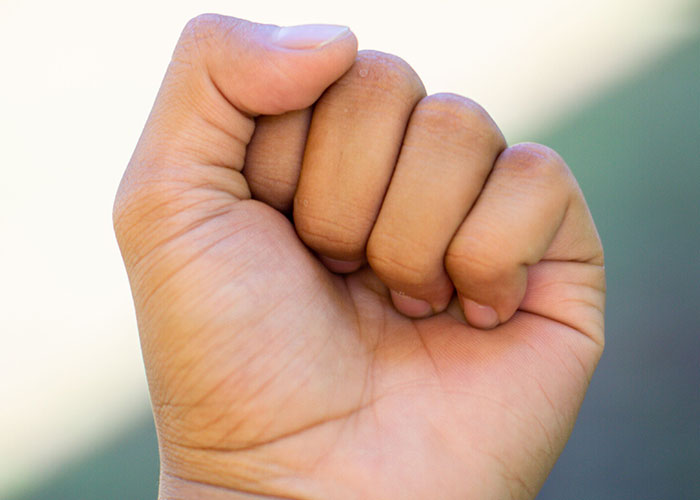A clenched fist, representing strength or anger related to the idea that family isn't everything.
