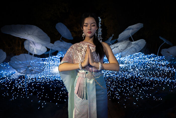 A woman in traditional attire amidst glowing lights, representing cultural stories of people in the 2025 Chromatic Awards.