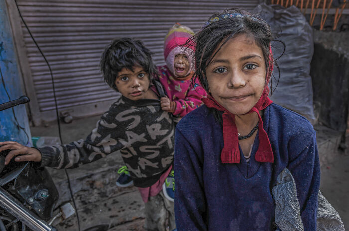 Three children with expressive faces, a powerful image telling stories of people, selected for the 2025 Chromatic Awards.