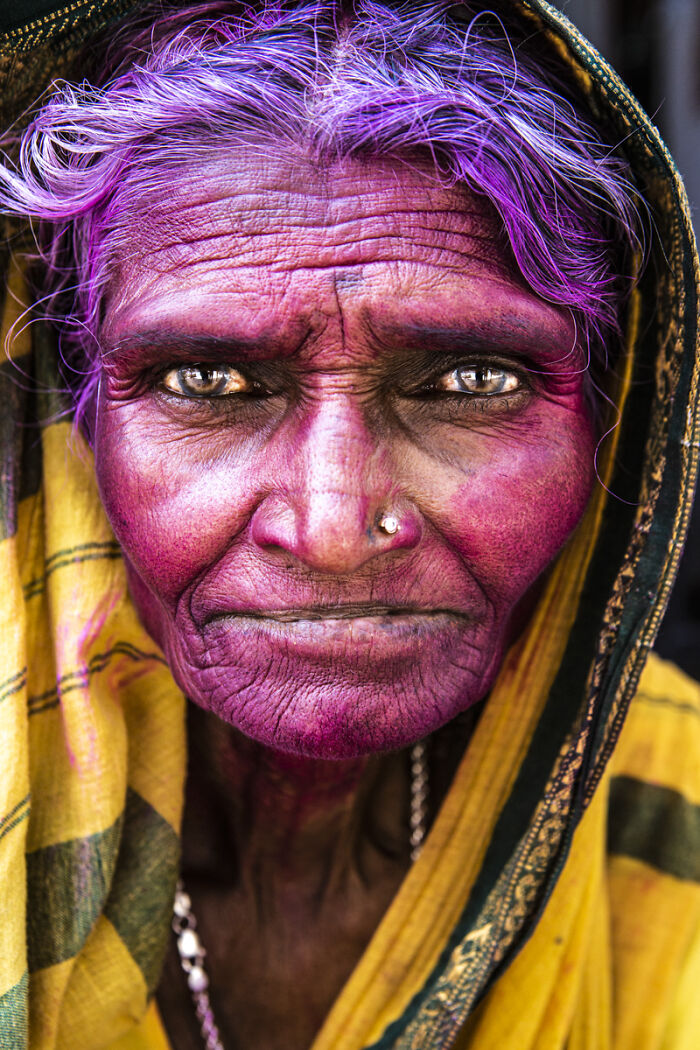 A woman with purple hair and pink-painted face looks directly at the camera, a captivating entry in the Chromatic Awards.