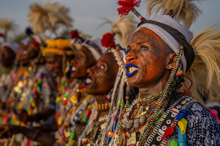 A line of individuals in vibrant traditional attire with painted faces, sharing the rich stories of people for the 2025 Chromatic Awards.