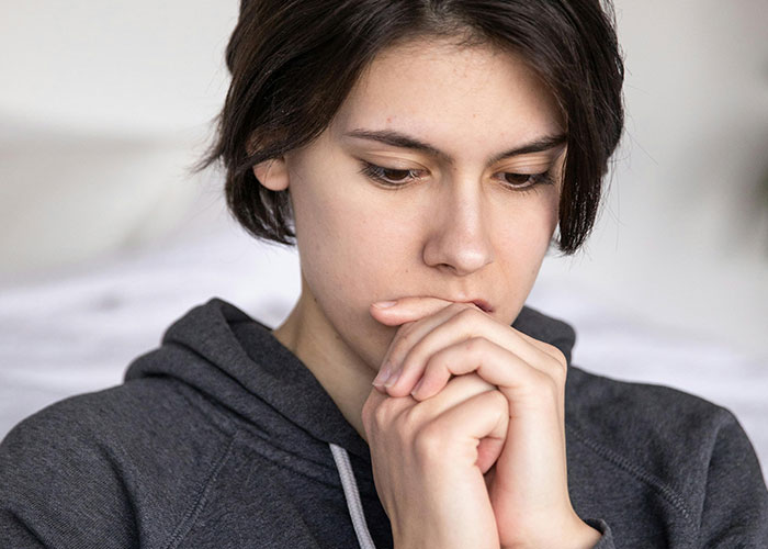 Pensive young person reflecting on personal wild secrets
