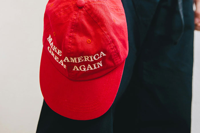 Close-up of red cap with political slogan making America great again