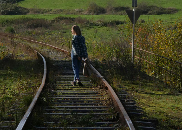 Woman walking on railroad tracks symbolizing legal offense risks