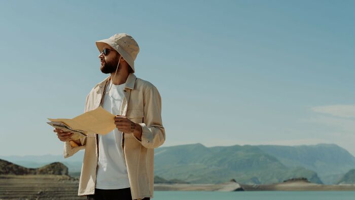 Man exploring with map in mountains, mind-bending dilemmas outdoor challenge