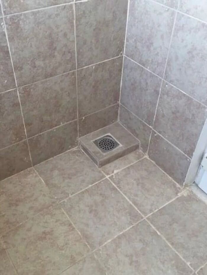 Bathroom floor drain raised above tiled floor causing poor drainage