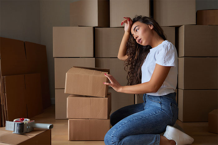 A frustrated woman is told to leave her home, surrounded by moving boxes, highlighting the rule refusal.