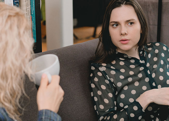 Two close friends discussing horrible things that broke their trust, with one listening intently.