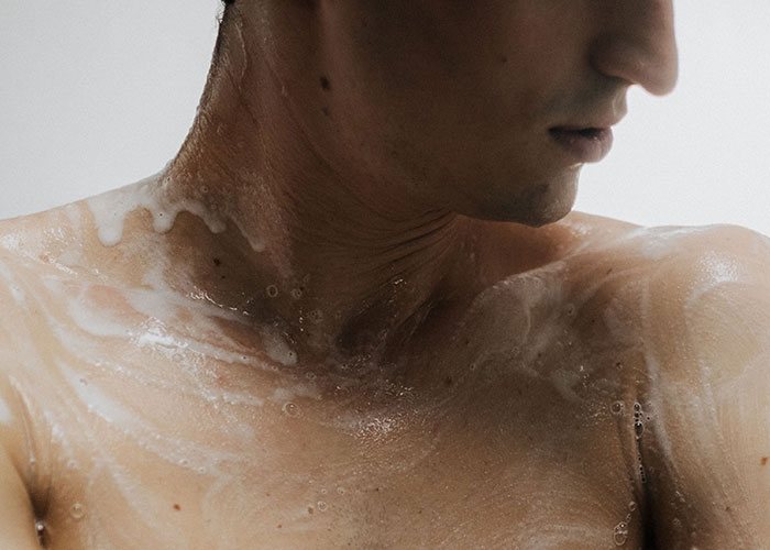 Man washing his upper body with soap showing hygiene detail Man washing his upper body with soap showing hygiene detail