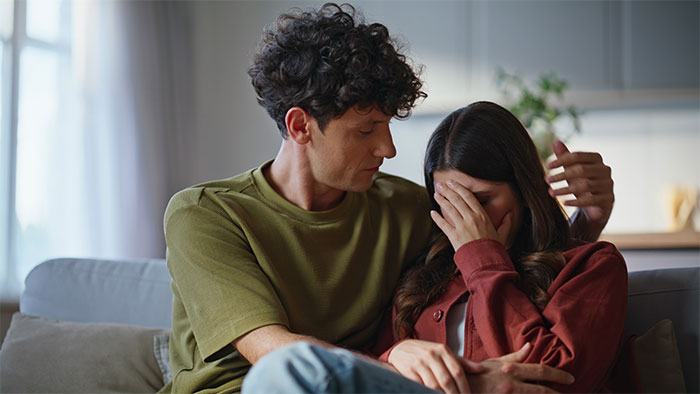 A man comforts a woman crying, illustrating the emotional fallout from a brother's fiancée's tantrum over a dress. A man comforts a woman crying, illustrating the emotional fallout from a brother's fiancée's tantrum over a dress.