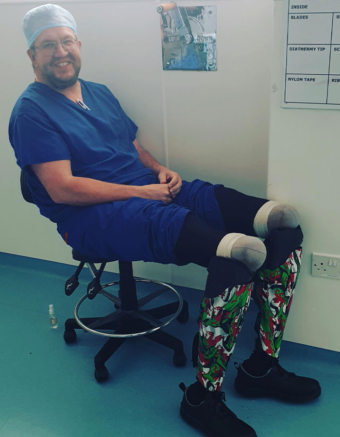 Man in surgical scrubs with prosthetic legs in medical setting about professional surgeon Man in surgical scrubs with prosthetic legs in medical setting about professional surgeon