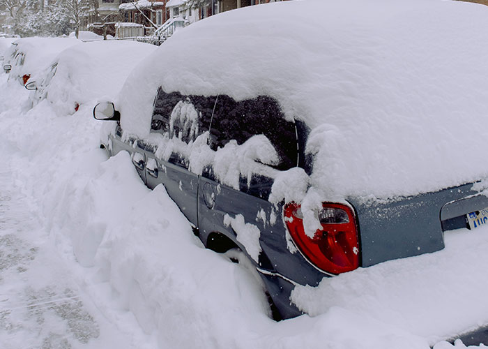 Car buried in snow after heavy snowstorm, winter parking