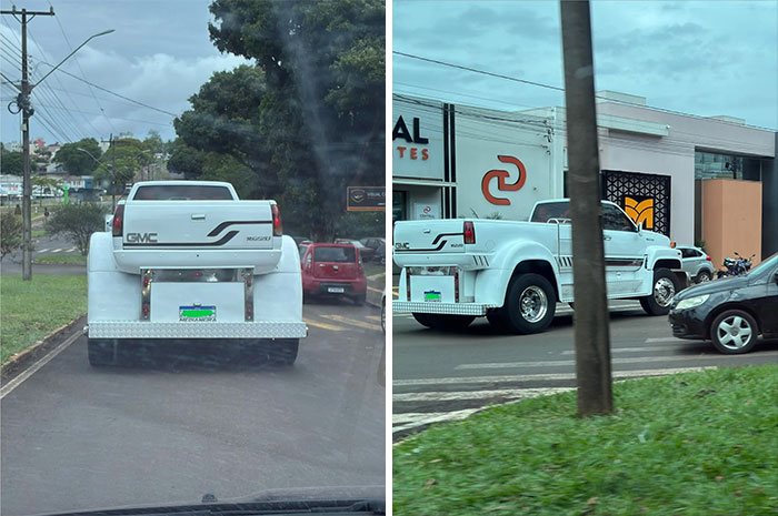 White GMC truck with a custom extended rear body on the road