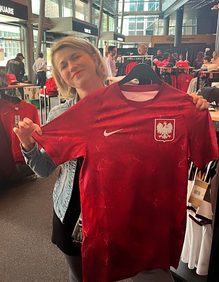 Woman holding Poland national team jersey at World Cup merchandise store