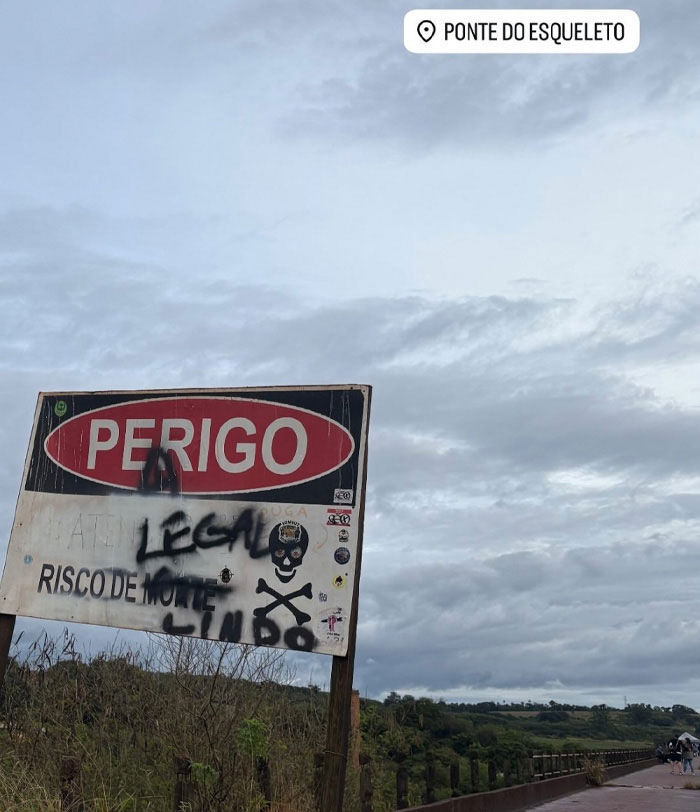 Warning sign reads DANGER and D***H RISK at Ponte do Esqueleto, related to rope jumping tragedy. Warning sign reads DANGER and D***H RISK at Ponte do Esqueleto, related to rope jumping tragedy.
