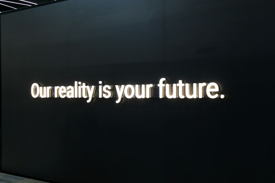Illuminated sign with text our reality is your future about mindset and relationships