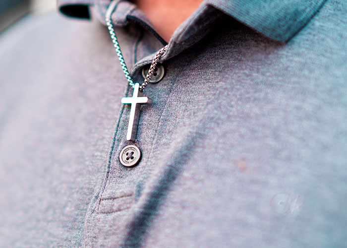 Close up of cross necklace suggesting time to leave immediately
