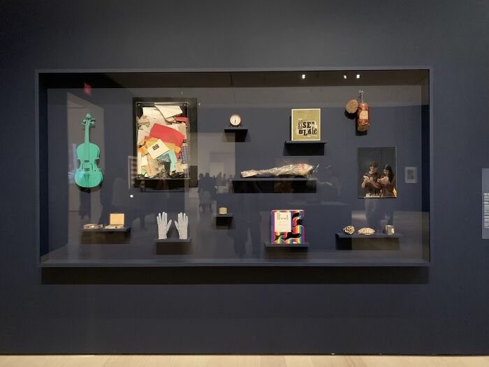 A display case features various objects including a green violin, illustrating the "Like A Painting" photo trend.