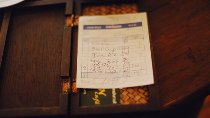 A handwritten bill inside a wooden box, representing the financial aspects and acceptable actions on a date.