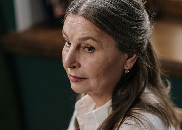 A close-up of a middle-aged woman looking intently, related to a woman's drunken tantrum.