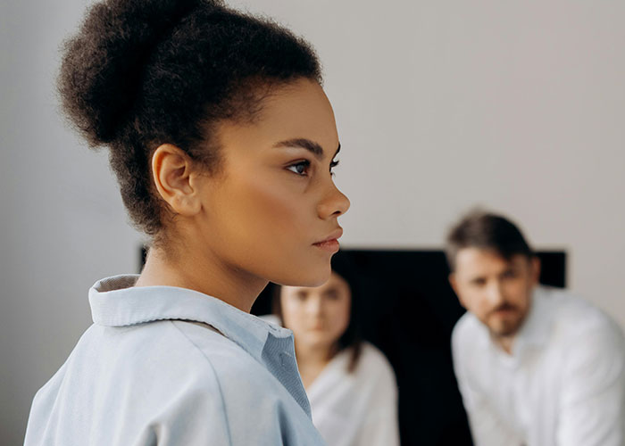 Young woman in thoughtful mood amid group, symbolizing wild secrets kept hidden